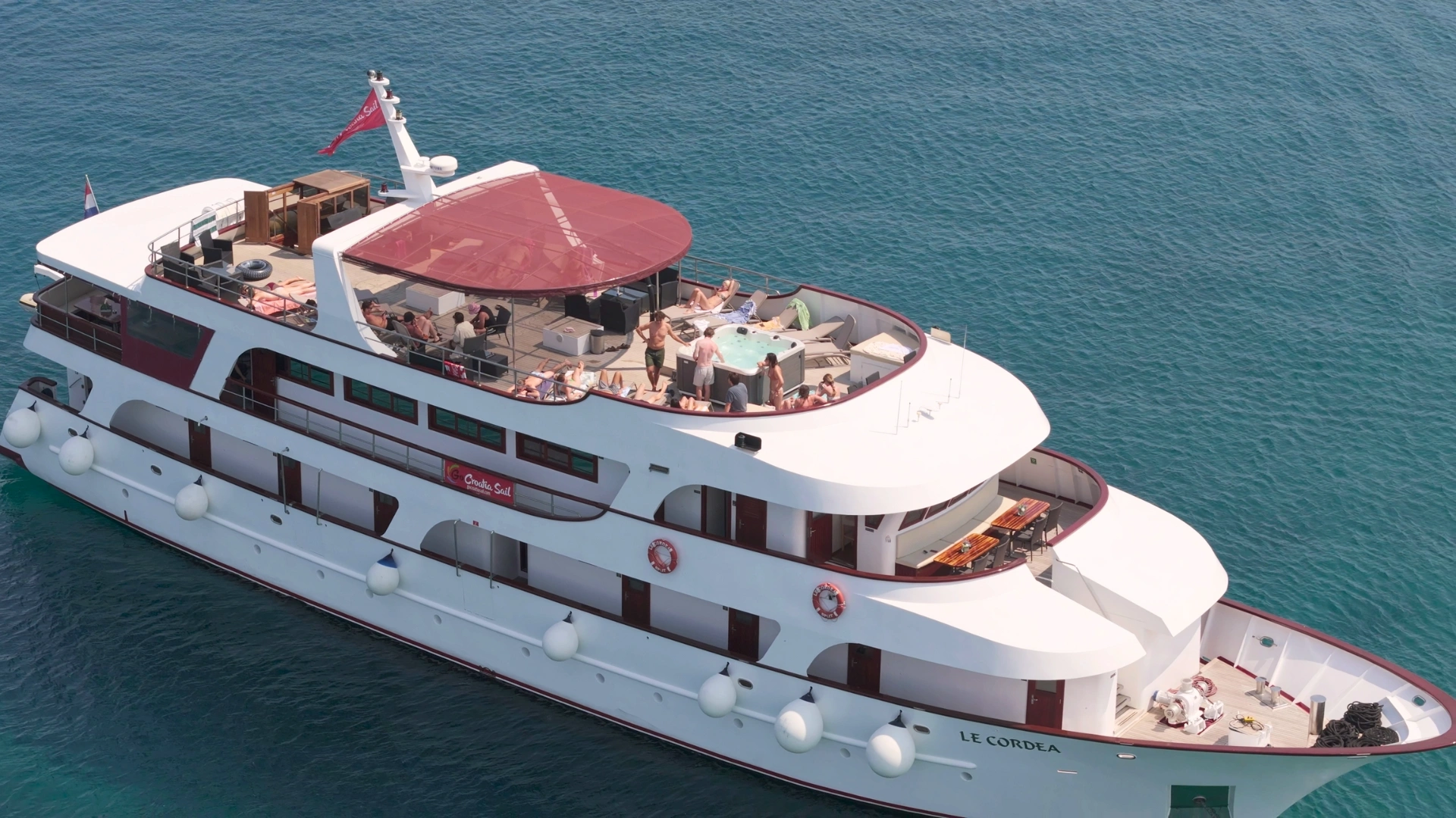 An areal shot of Go Croatia Sail Superior boat, Le Cordea, with people sunbathing on the top deck on a sunny day