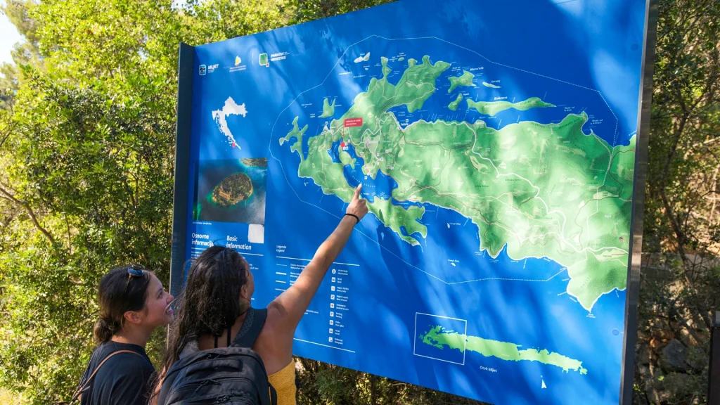 Tourists pointing on a Mljet National Park Map during small ship cruise.